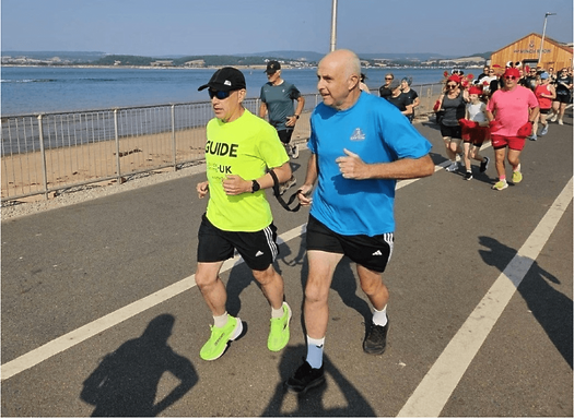 Robert running Exmouth parkrun with his VI guide